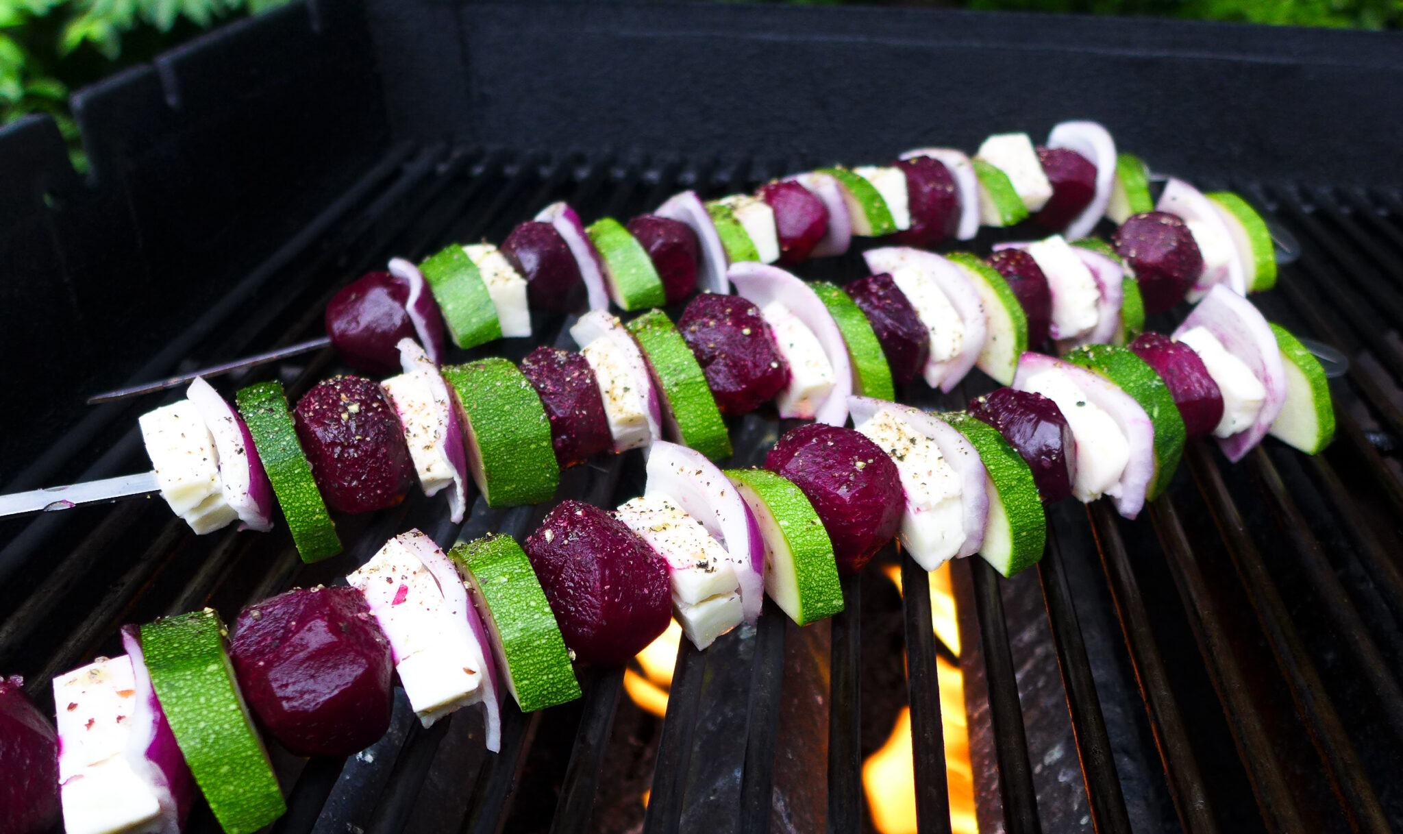 Skewers of beets, zucchini and halloumi cheese in a gas grill