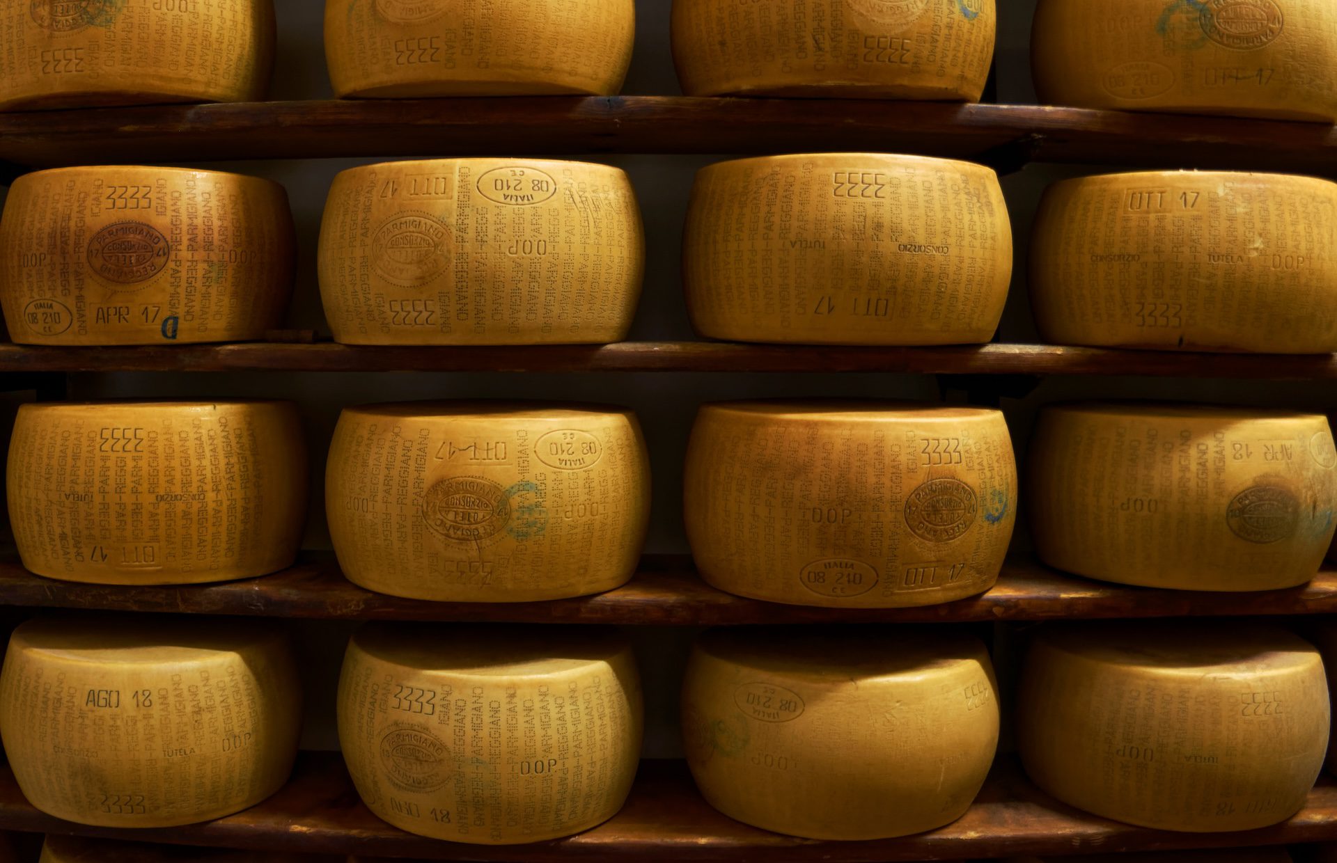 wheels of parmigiana reggiano cheese on shelves