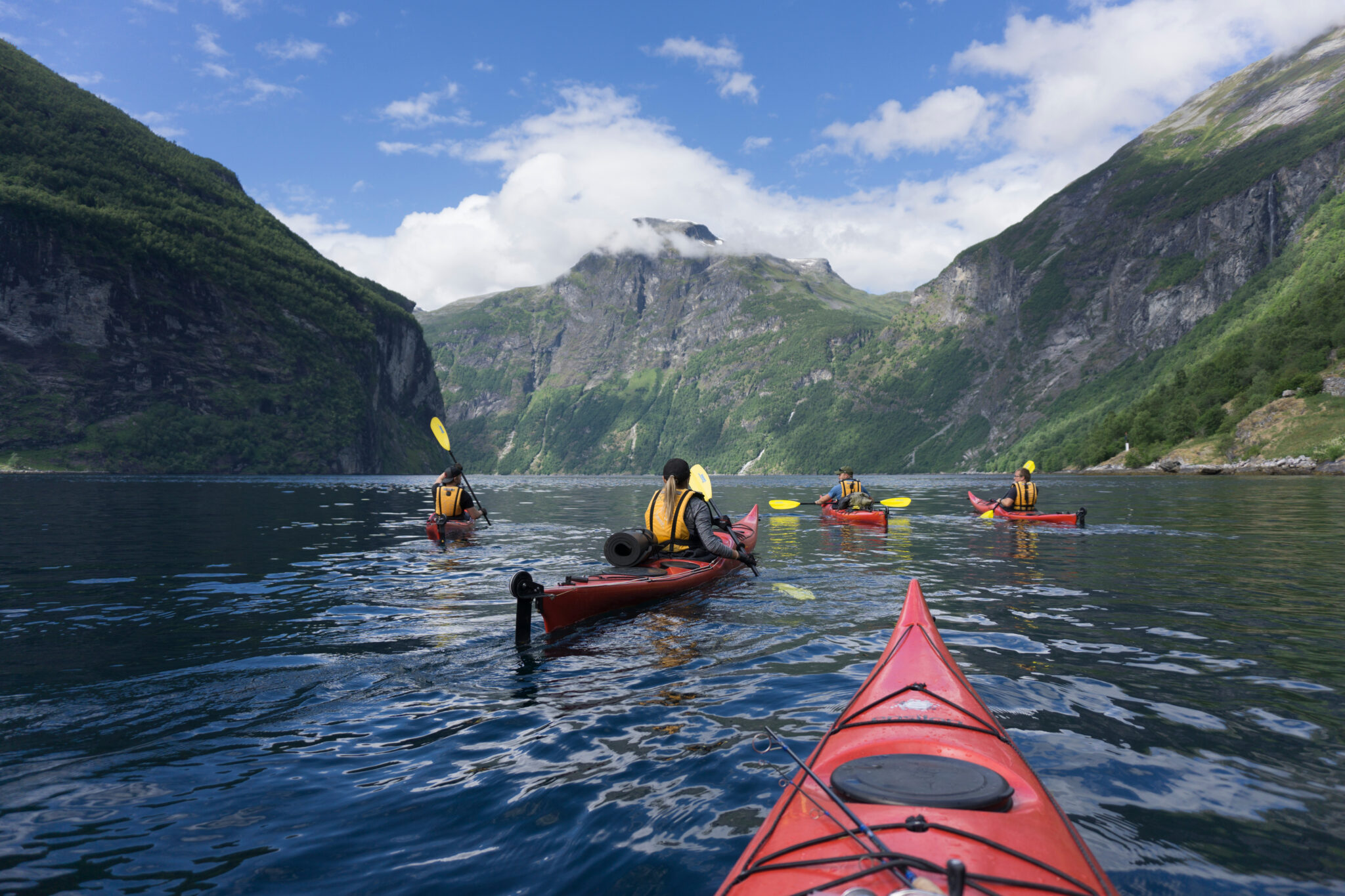 group of kayaks paddling in a fjord