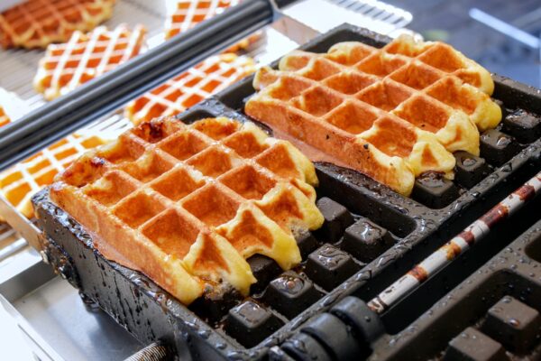 Two,Liege,Waffles,Baking,On,Their,Mold.