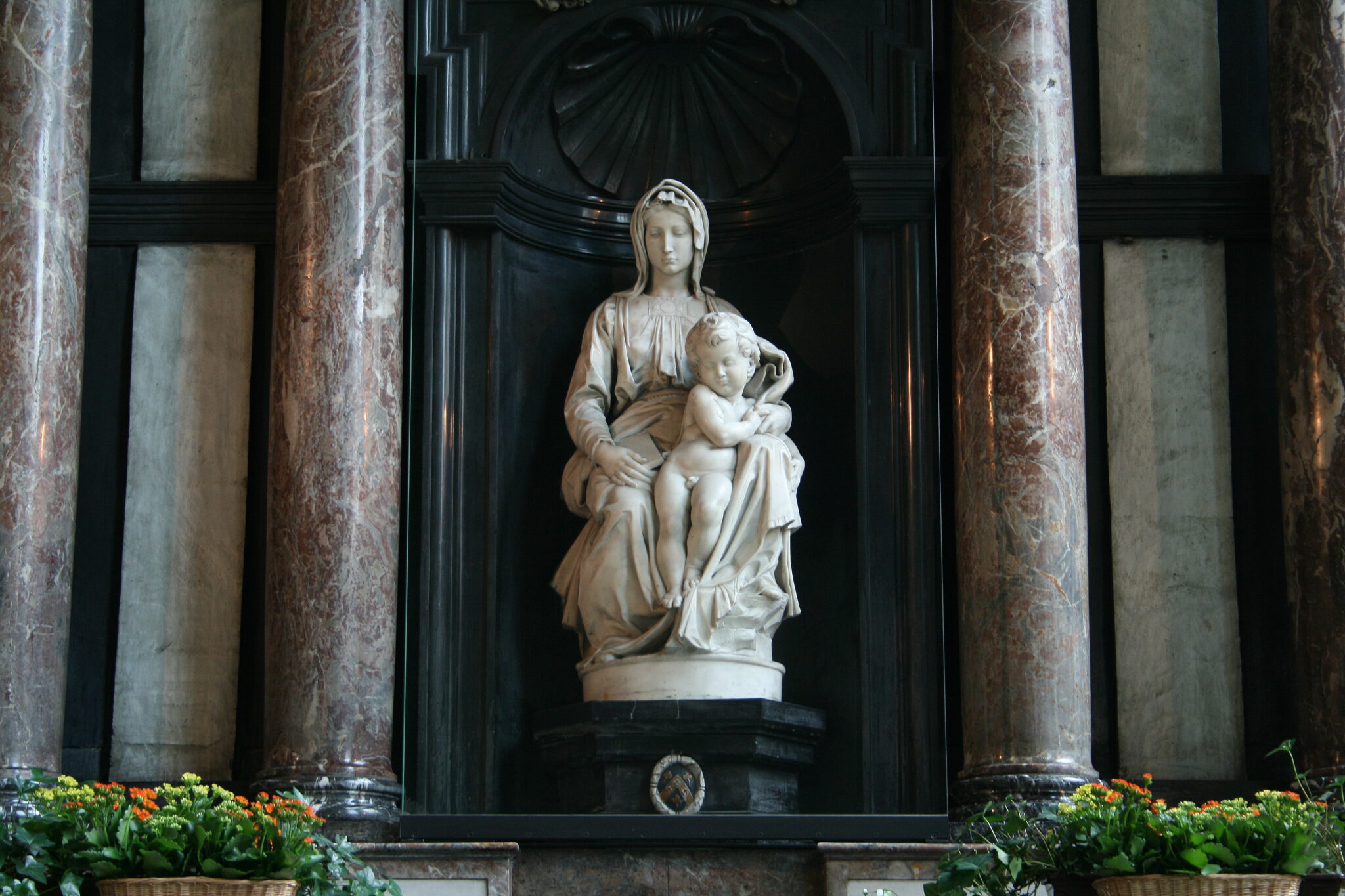 marble statue of Madonna and child in dark niche