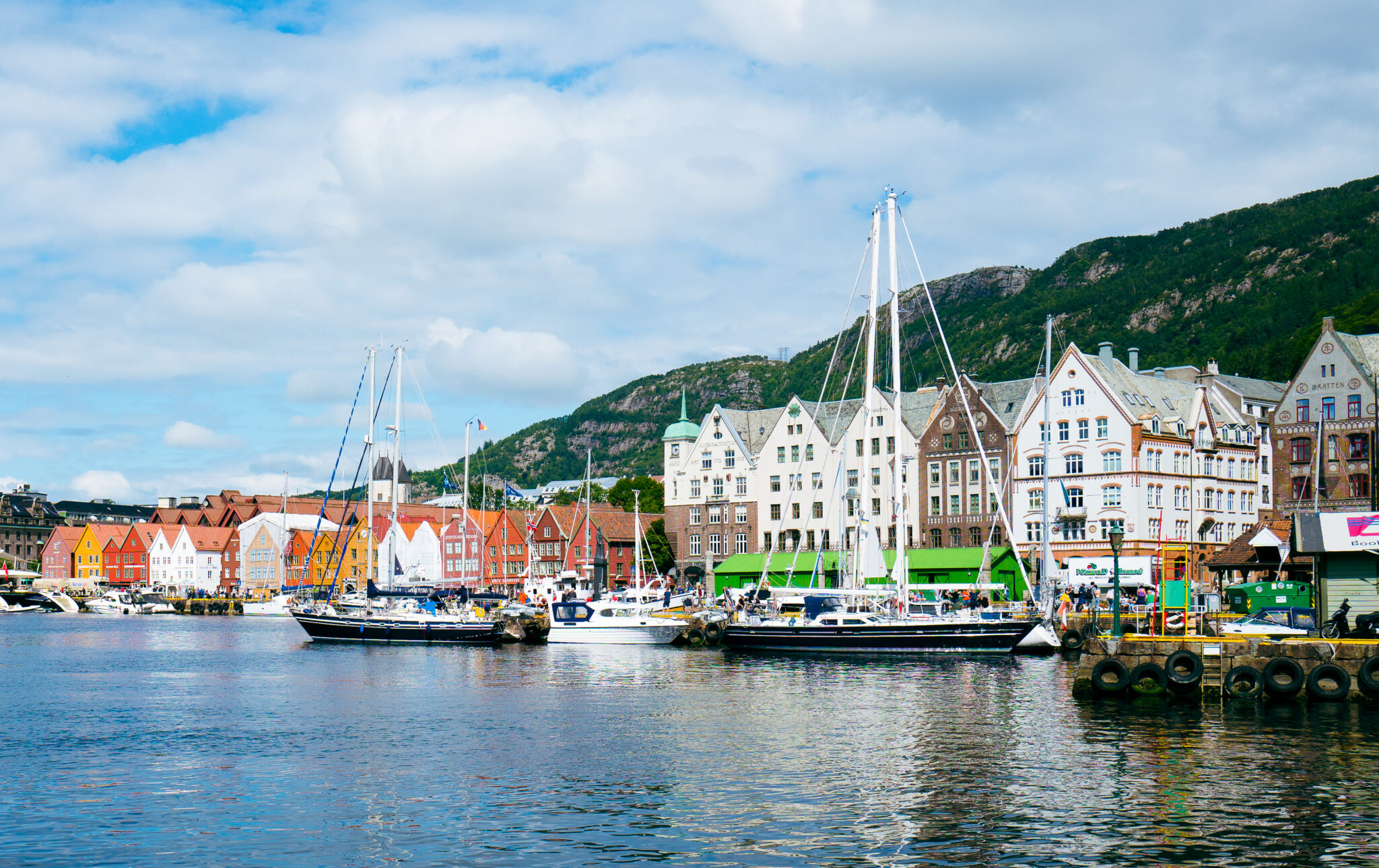 View of stone buildings across a body of water with sailing ships in Bergen Ireland